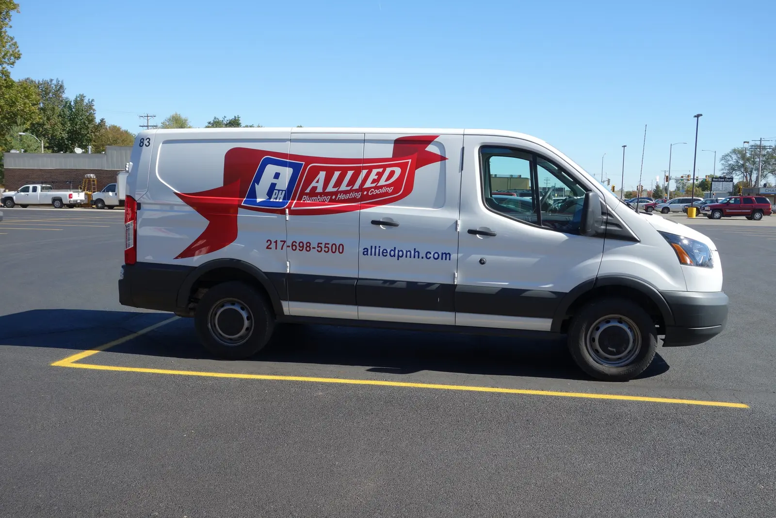 Allied Plumbing, Heating & Cooling service van wrapped in the red ribbon logo, parked and ready to dispatch