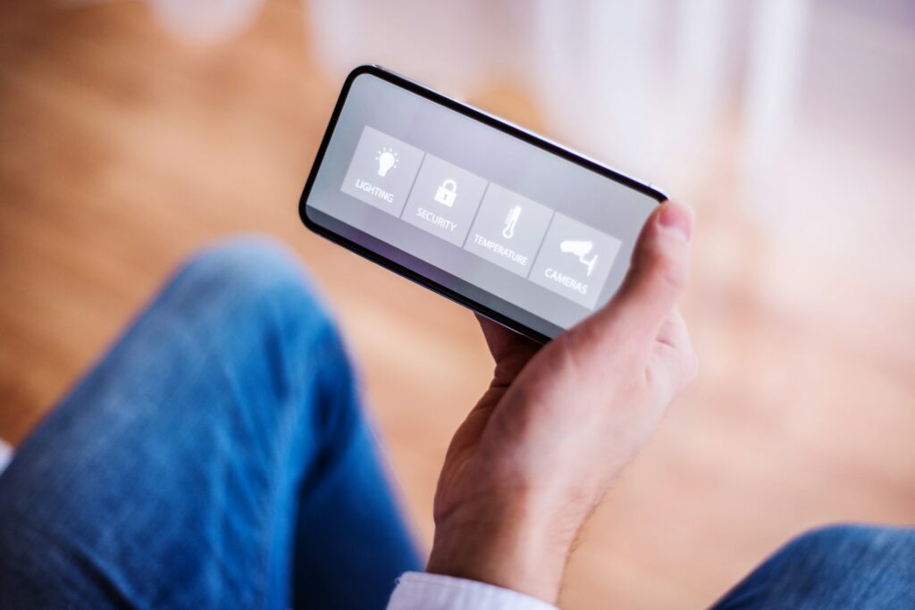 Why Your Smart Thermostat Won't Hold Temperature Settings in Sherman 7 Person holding a smart device displaying HVAC control options for lighting, security, temperature, and cameras, emphasizing modern home automation solutions.